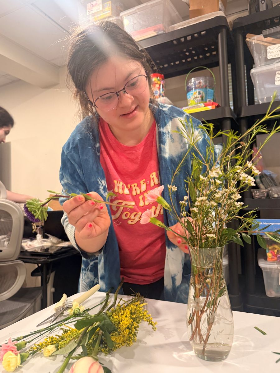 A team member trimming and choosing flowers for an arrangement