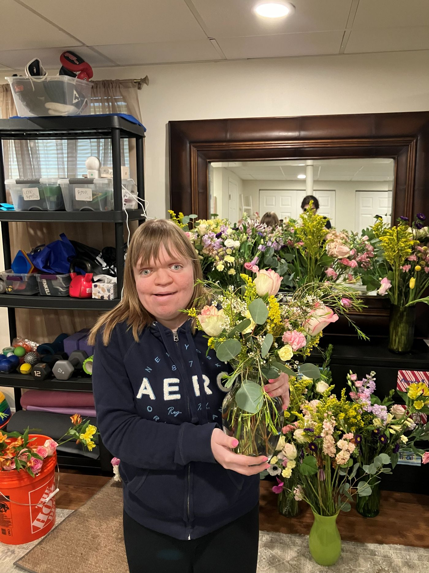 A floral team member holding the arrangement she designed