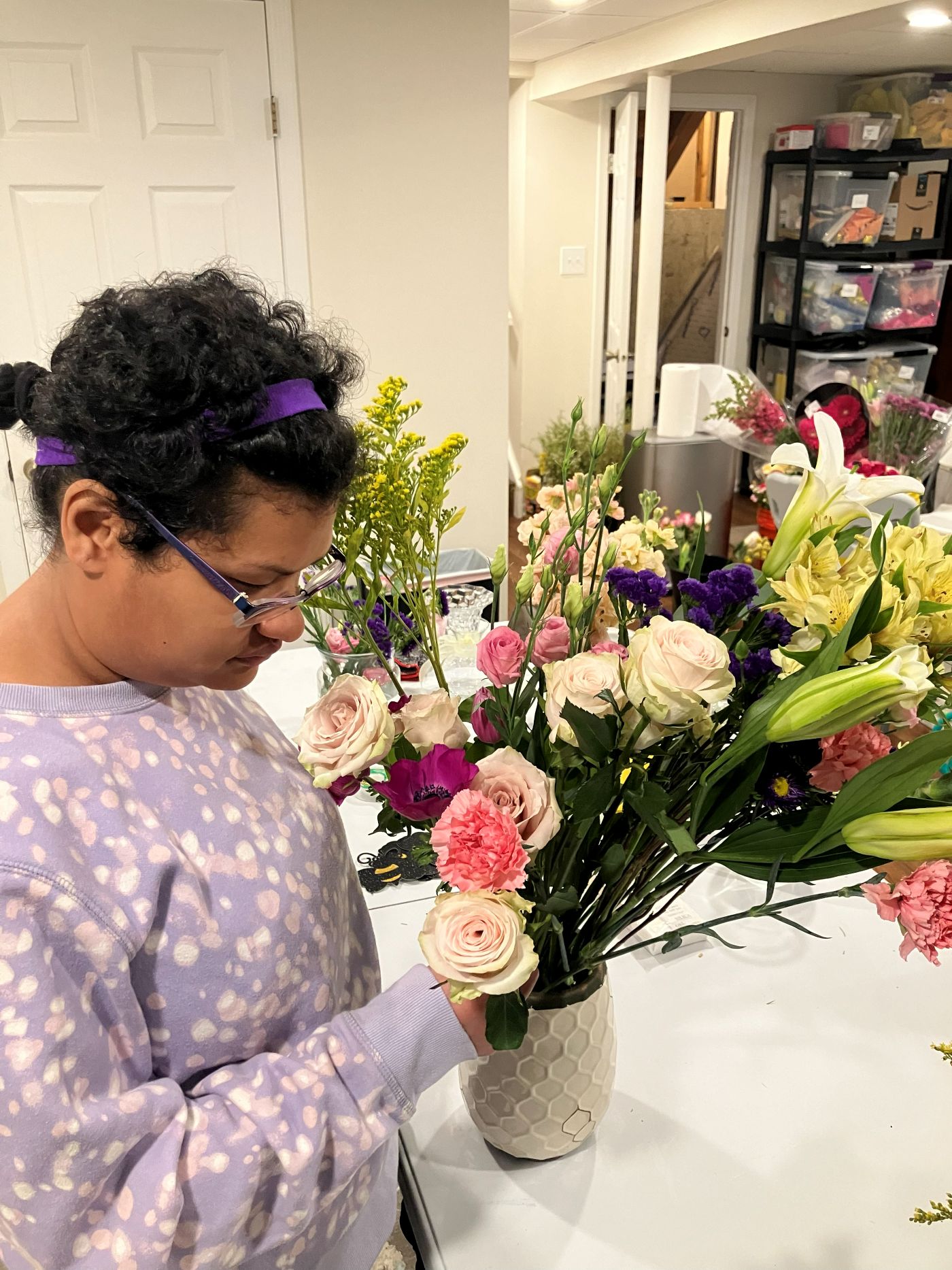A floral team member carefully placing roses into a vase