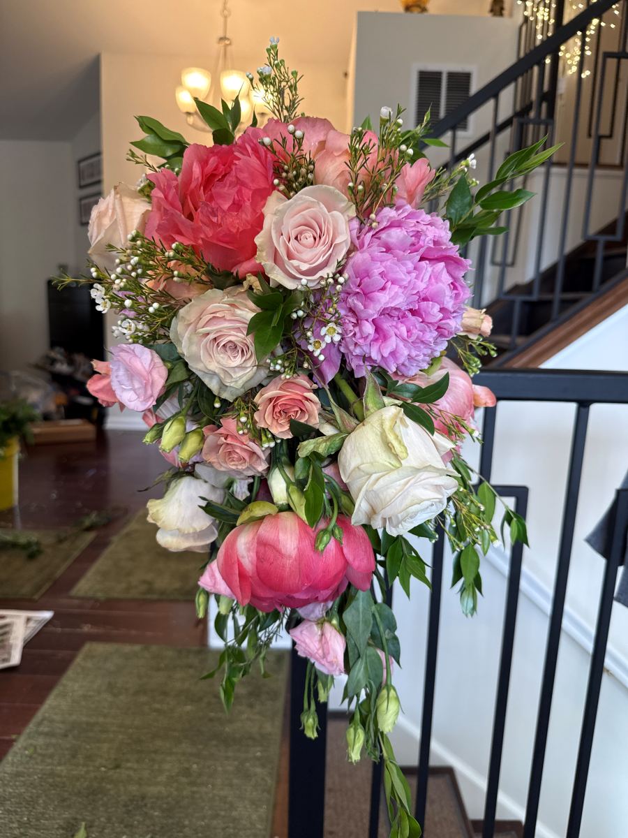A cascading bridal bouquet of peonies and roses made by our team